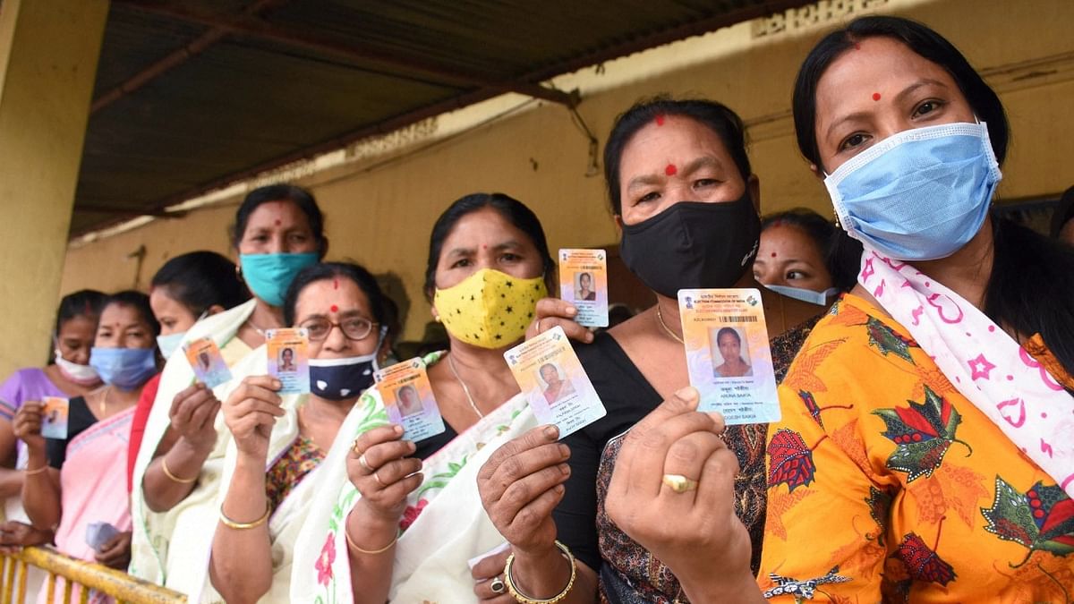 Voters stand in a queue at a polling station to cast their votes for the first phase of Assam Assembly elections in Dibrugarh district. Credit: PTI Photo