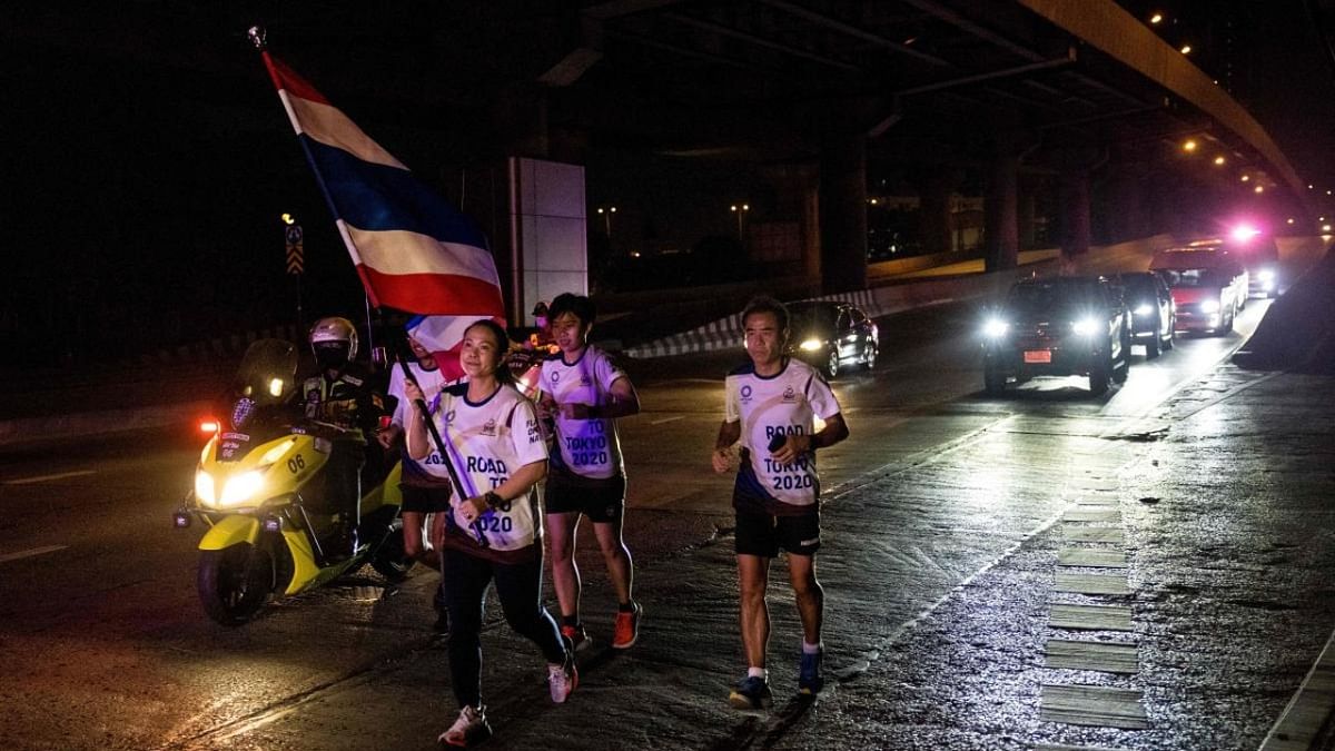 Olympic gold medallist Pawina Thongsuk runs with the Thai national flag during the