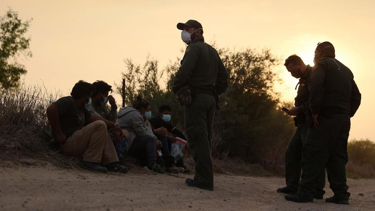US Border Patrol agents process a group of people they caught crossing the border from Mexico on March 27, 2021 in Penitas, Texas. Credit: AFP.
