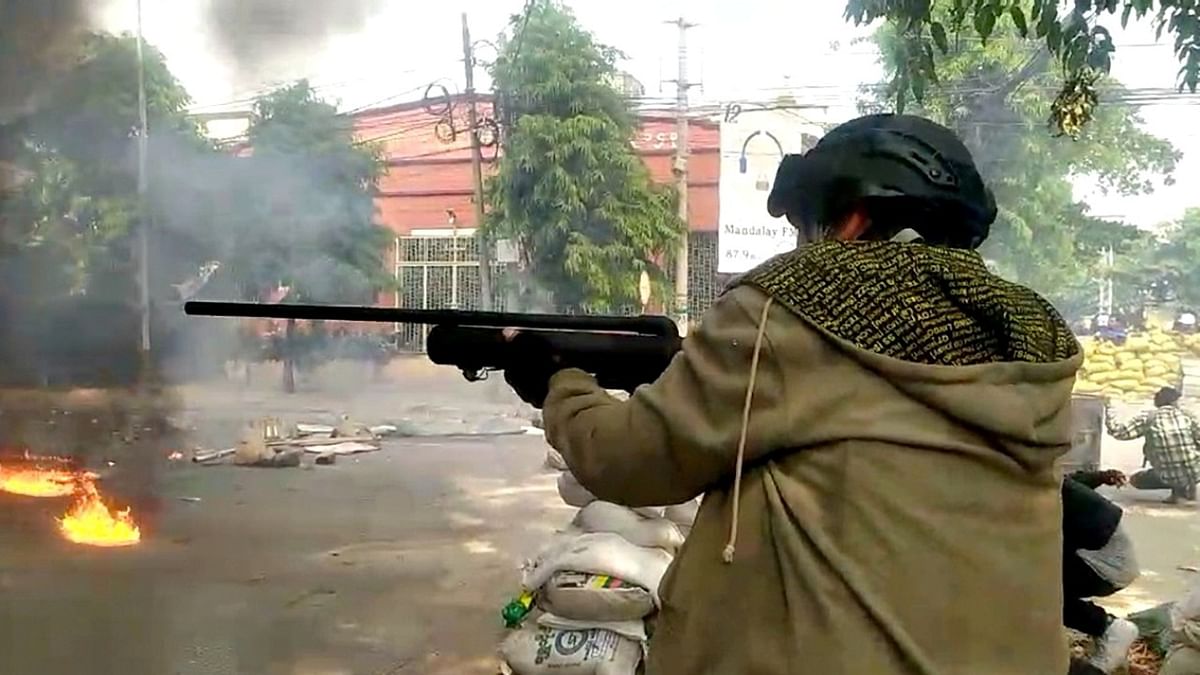 A protester fires a homemade air gun during a protest against the military coup, in Mandalay, Myanmar in this still image taken from video obtained by Reuters.