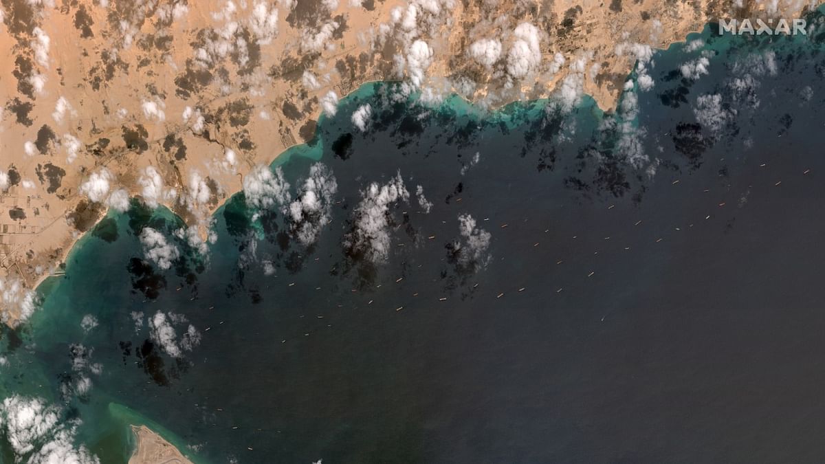 A general view of the ships waiting south of the Suez Canal due to the grounded Ever Given container ship, which is seen at far left stuck in the canal near Port Tawfiq and the city of Suez, Egypt in this Maxar Technologies satellite image taken on March 28, 2021. Credit: Satellite image (copyright) 2021 Maxar Technologies/Reuters