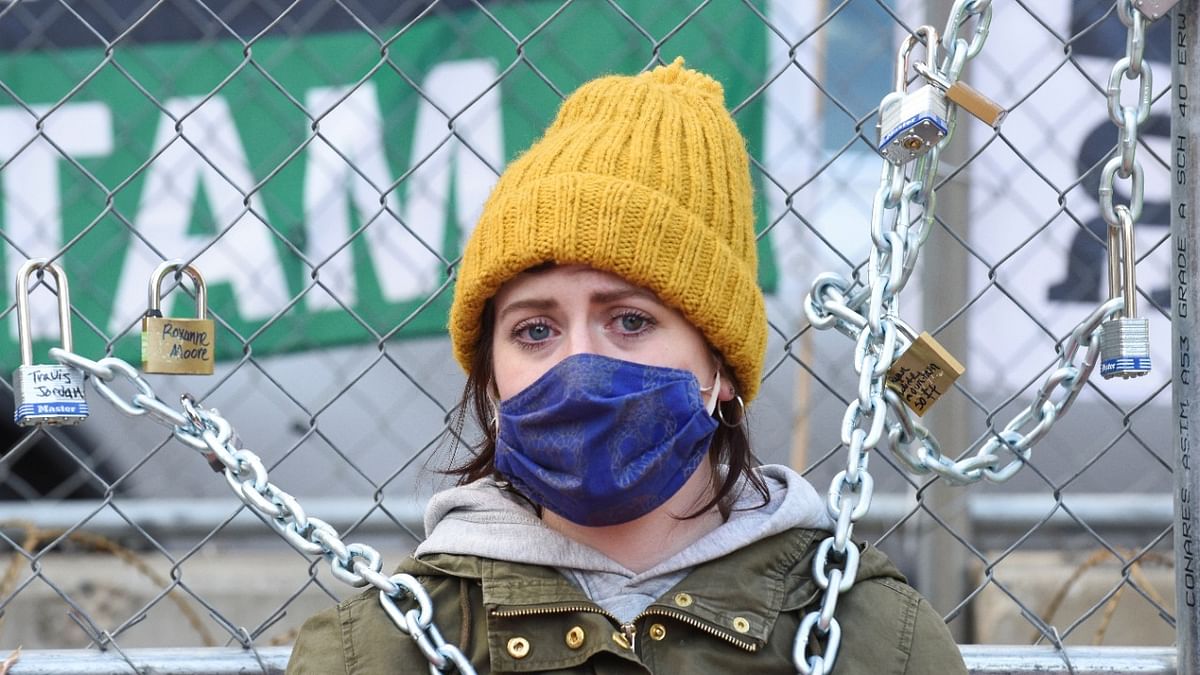 Grace Busse takes the place of her former high school teacher Kaia Hirt, who chained herself to a fence outside the Hennepin County Government Center yesterday in protest, after the second day in the trial of former police officer Derek Chauvin, who is facing murder charges in the death of George Floyd, in Minneapolis, Minnesota. Credit: Reuters Photo