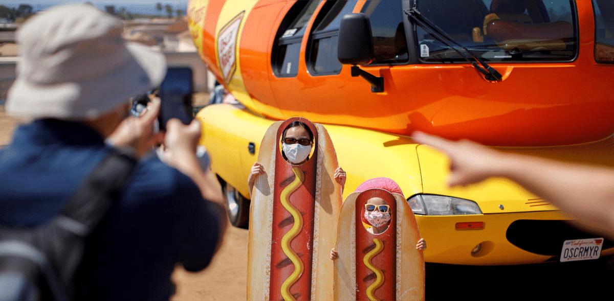 A family takes a picture at the Oscar Myer Wienermobile during a visit to
