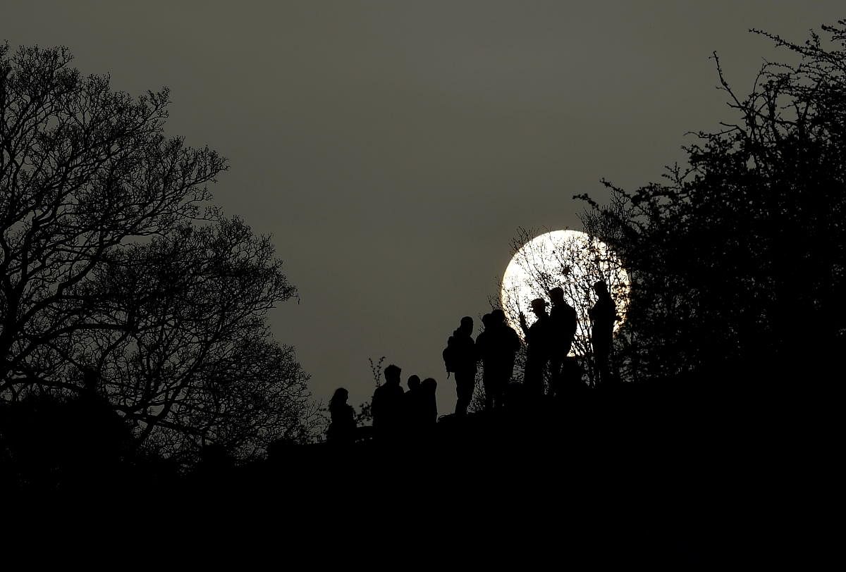 People socialise in Primrose Hill park with the sun seen behind, as lockdown restrictions are eased in England, amid the spread of the coronavirus disease in London. Credit: Reuters photo.