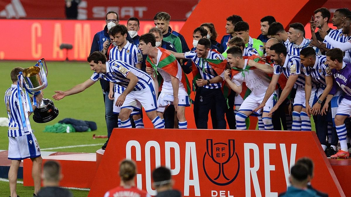 Real Sociedad's players celebrate with the trophy after winning the 2020 Spanish Copa del Rey (King's Cup) final football match between Athletic Bilbao and Real Sociedad at La Cartuja stadium in Sevilla. Credit: AFP Photo