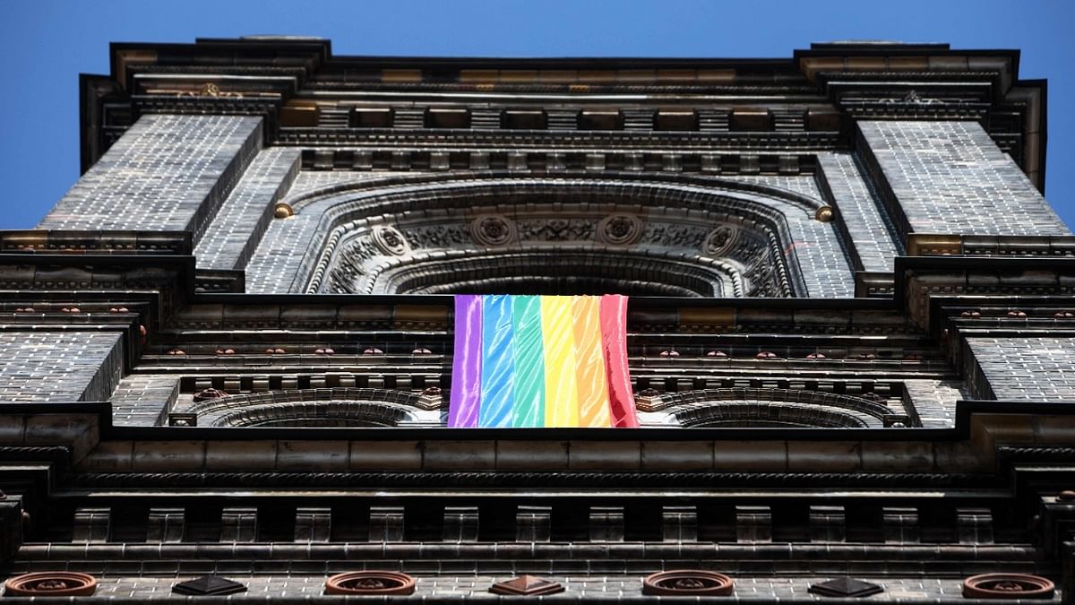 A LGBT rainbow flag hangs from on the steeple of the parish church in the Breitenfeld quarter in Vienna. Credit: AFP Photo