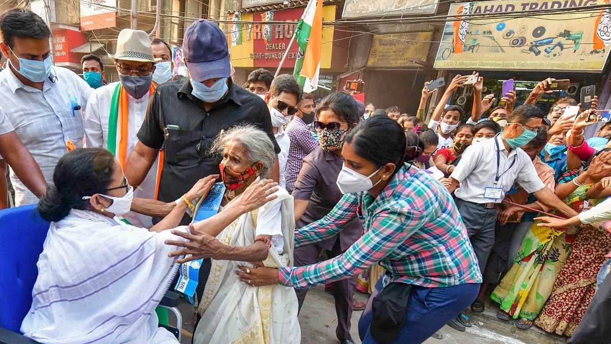 West Bengal CM and TMC supremo Mamata Banerjee interacst with an elderly voter during an election campaign road show for Assembly polls, in Howrah district. Credit: PTI Photo