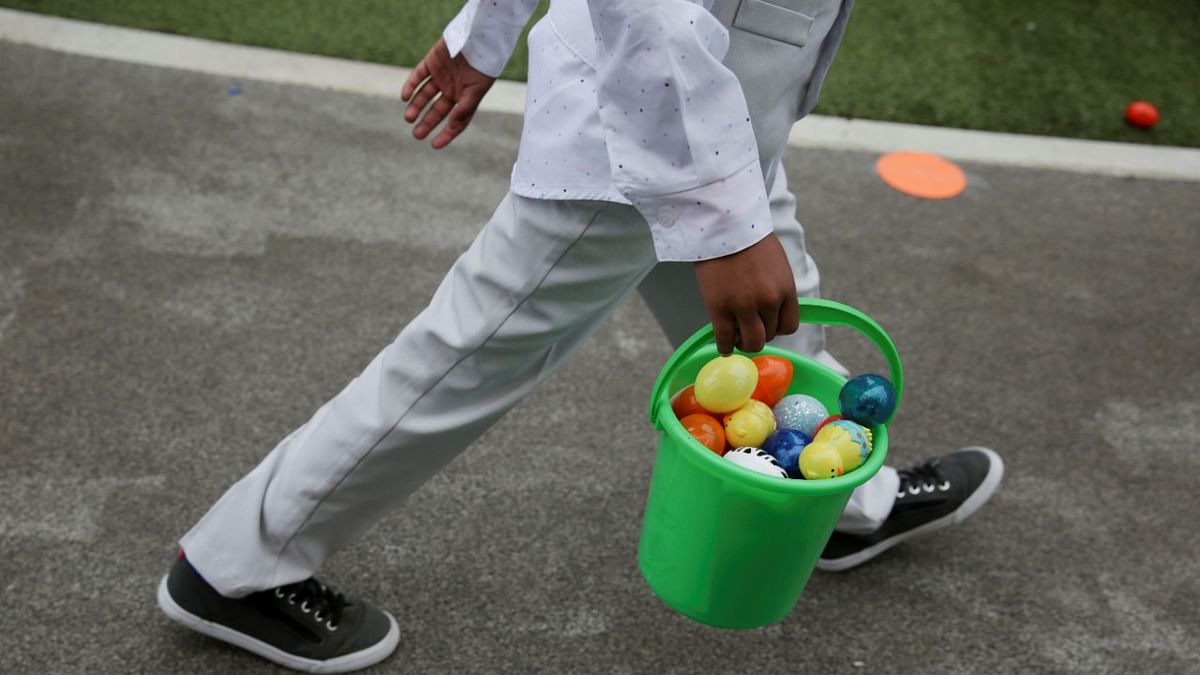 Children take home baskets of candy-filled eggs at an Easter egg hunt held by St. Luke