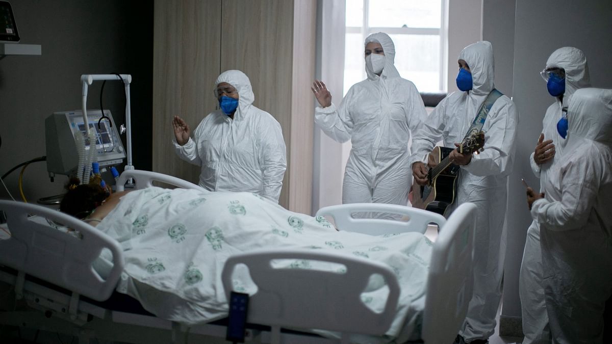 Health workers from the Portuguese charity hospital in Belem, Para State, Brazil, sing and pray for a Covid-19 patient inside the hospital wards and ICU areas as part of Easter celebrations. Credit: AFP Photo