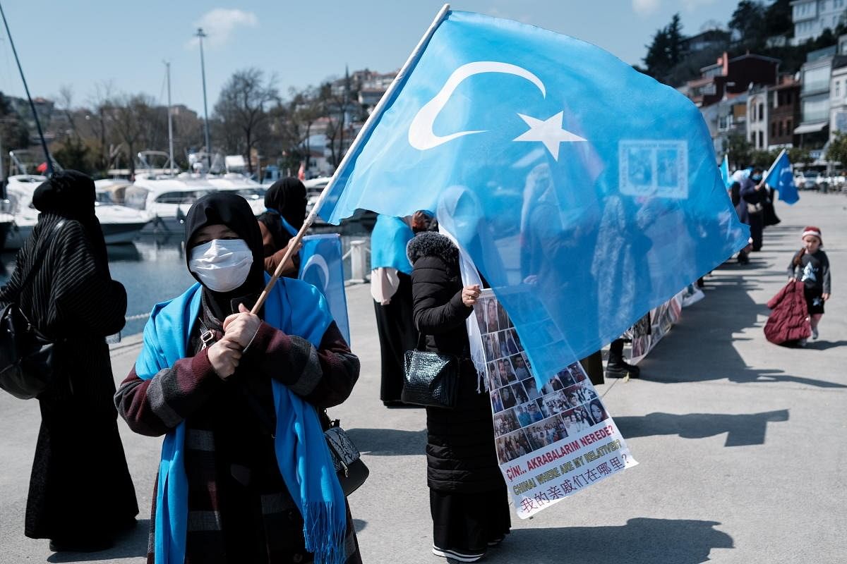 An ethnic Uighur woman waves an East Turkestan flag during a protest against China near the Chinese Consulate in Istanbul. Credit: Reuters Photo