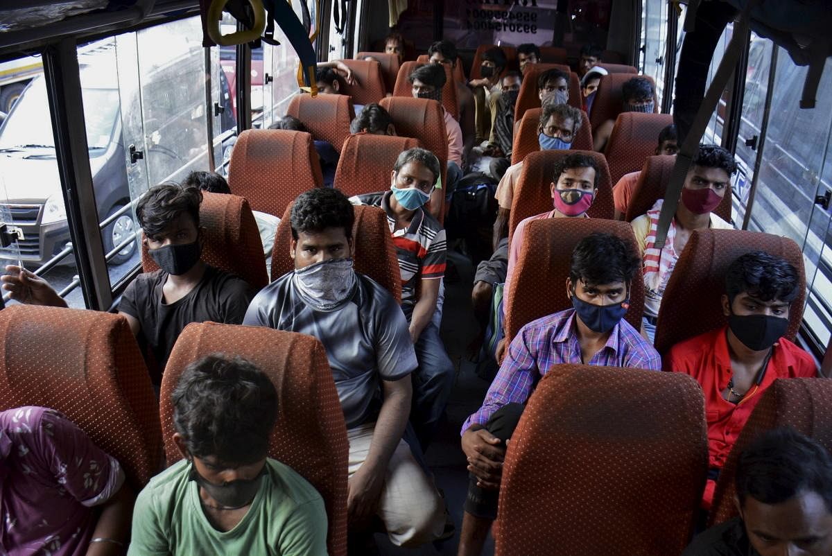 Migrant workers travel in a bus to leave for their home states, amid surge in Covid-19 cases, in Thane. Credit: PTI Photo