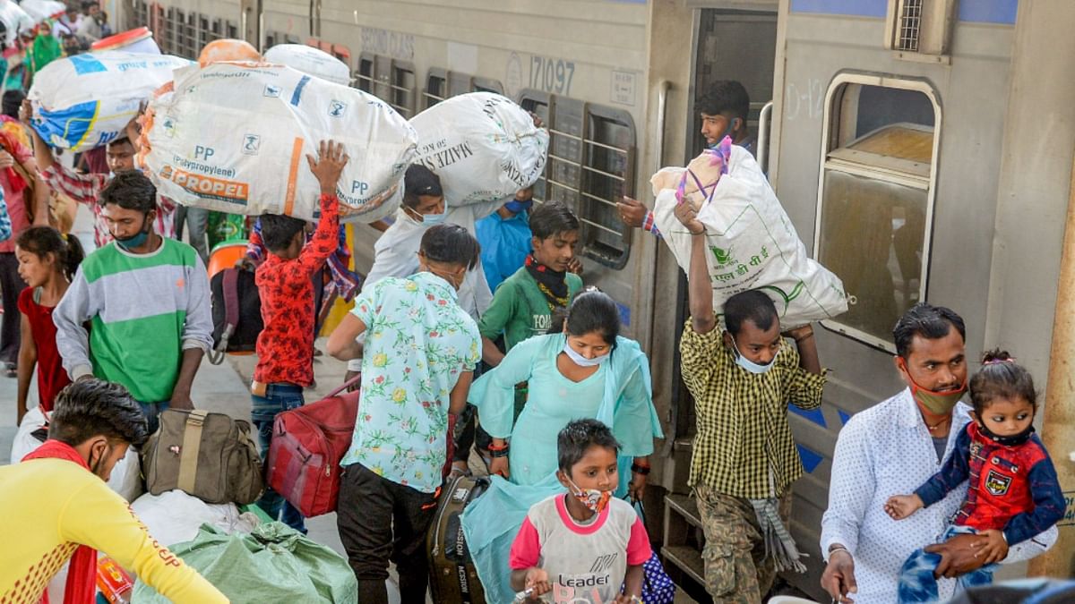 Migrants in Jalandhar board a train to leave for their home states, amid rise in Covid-19 cases across the country, at Jalandhar City railway station. Credit: PTI Photo