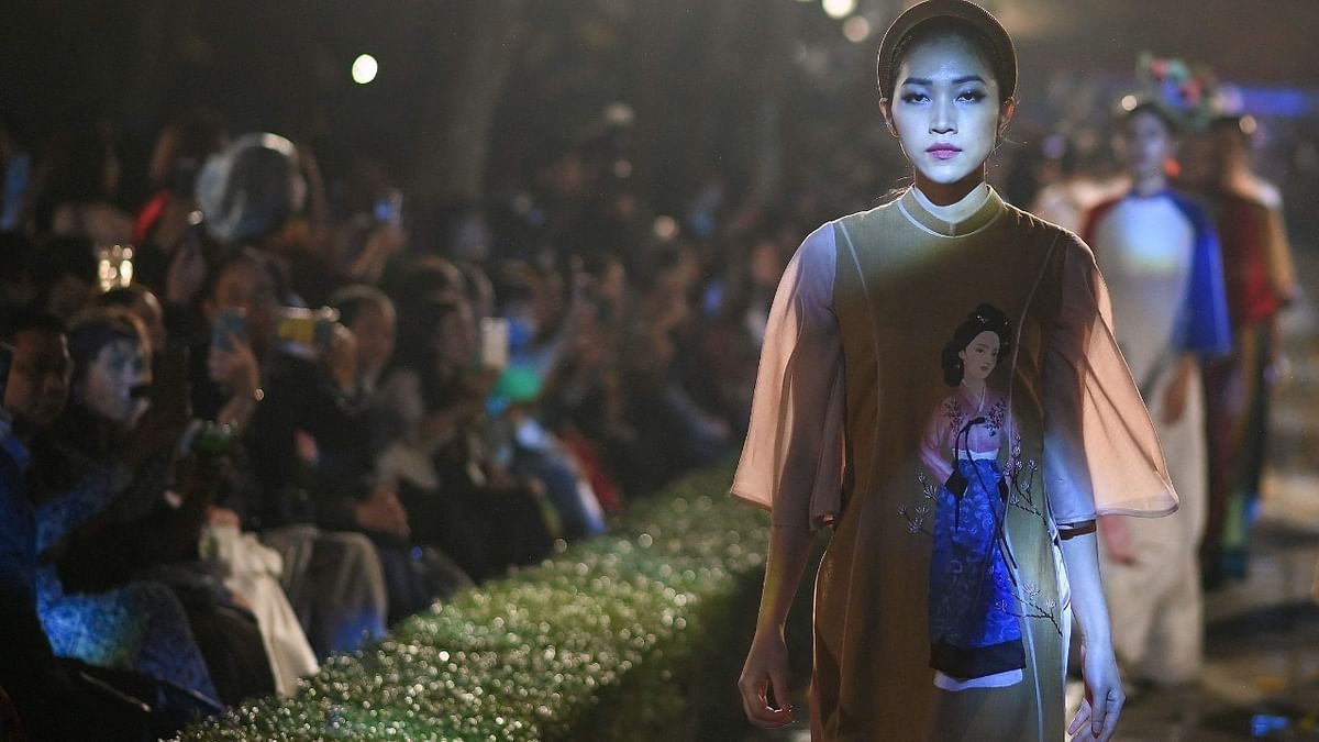 In this picture taken on April 9, 2021, a model dressed in Vietnam’s traditional Ao Dai dress presents a South Korea-inspired creation by designer Tran Thien Khanh during the 'World in Vietnamese Ao Dai' fashion show at the centuries-old Temple of Literature in Hanoi. Credit: AFP.