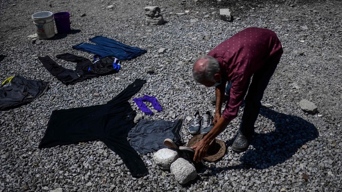A Central American migrant puts his washed clothes to dry outside the Sagrada Familia shelter while waiting for the so-called La Bestia (The Beast) cargo train, in an attempt to reach the US border, in Apizaco, Tlaxcala state, Mexico. Credit: AFP.