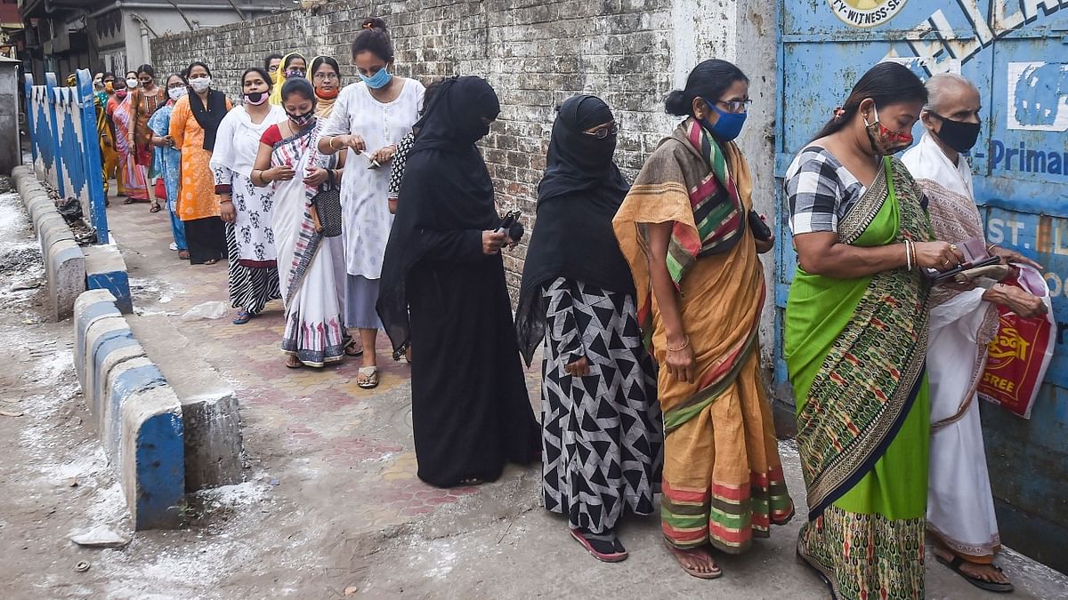 Voters stands in queue to cast their vote at a polling booth during fourth Phase of State Assembly poll in Kolkata. Credit: PTI Photo