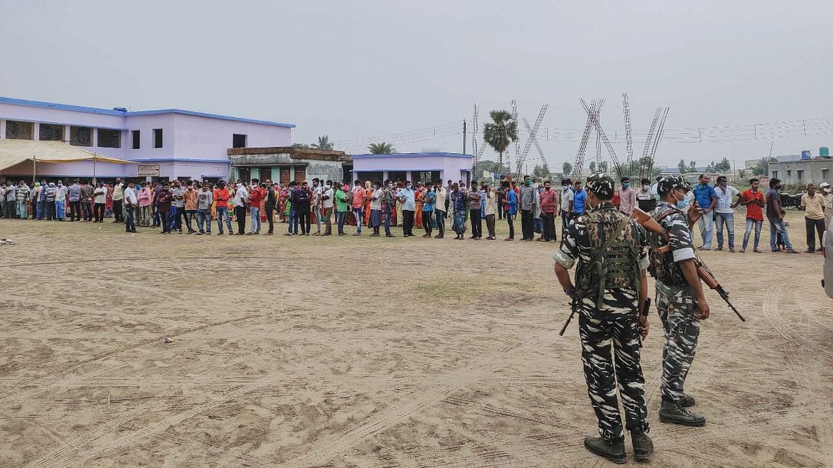 Security personnel stand a guard at a polling station during the fourth phase of West Bengal Assembly elections, at Bangra Chakra village in South 24 Parganas district. Credit: PTI Photo