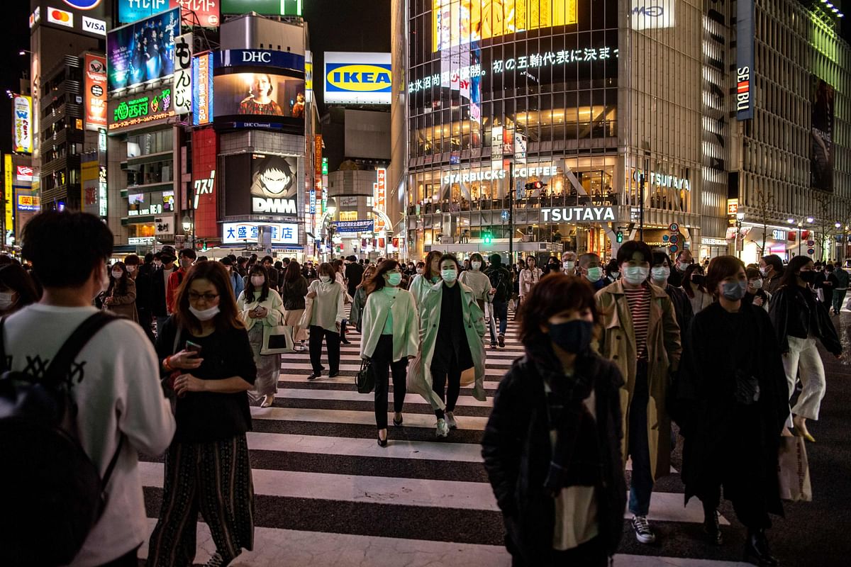 Pedestrians walk on the street in Shibuya district of Tokyo as Japan's government approved tighter coronavirus measures for the capital and other areas. Credit: AFP Photo
