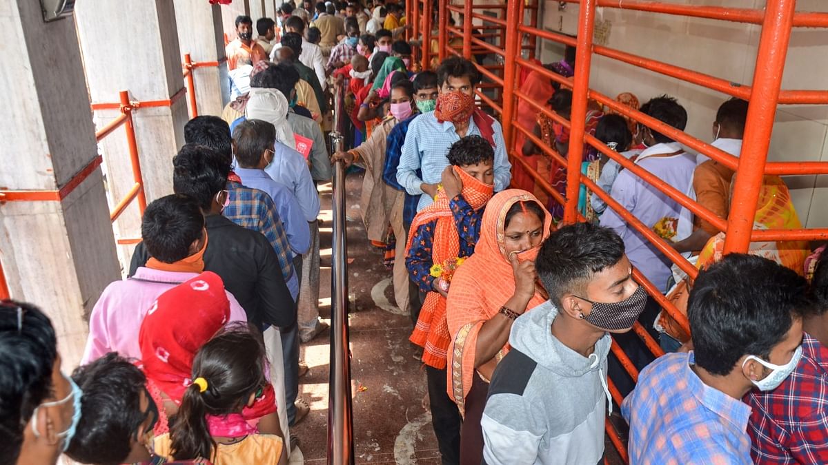 Devotees, wearing face masks, wait in queues to offer prayers at Vindhyavasini Temple on the first day of Navratri festival, amid the ongoing coronavirus pandemic, in Mirzapur.