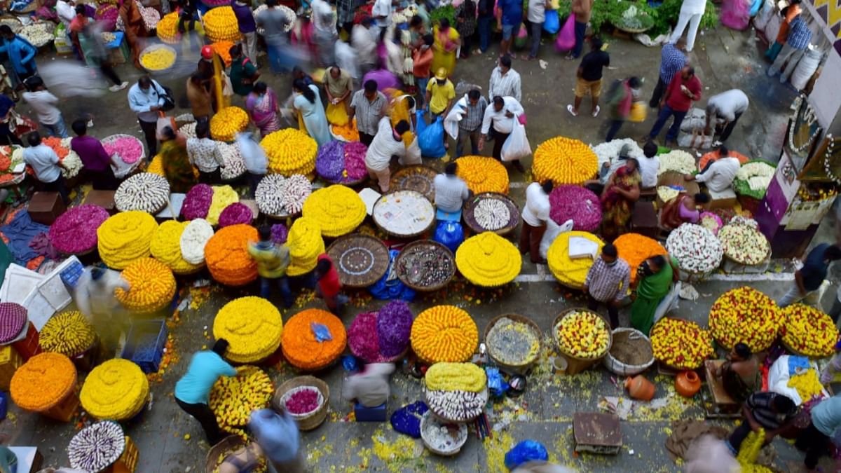 Citizens buy flowers ahead of Ugadi festival at a wholesale market amid surge in coronavirus cases at Bengaluru city railway station. Credit: PTI Photo
