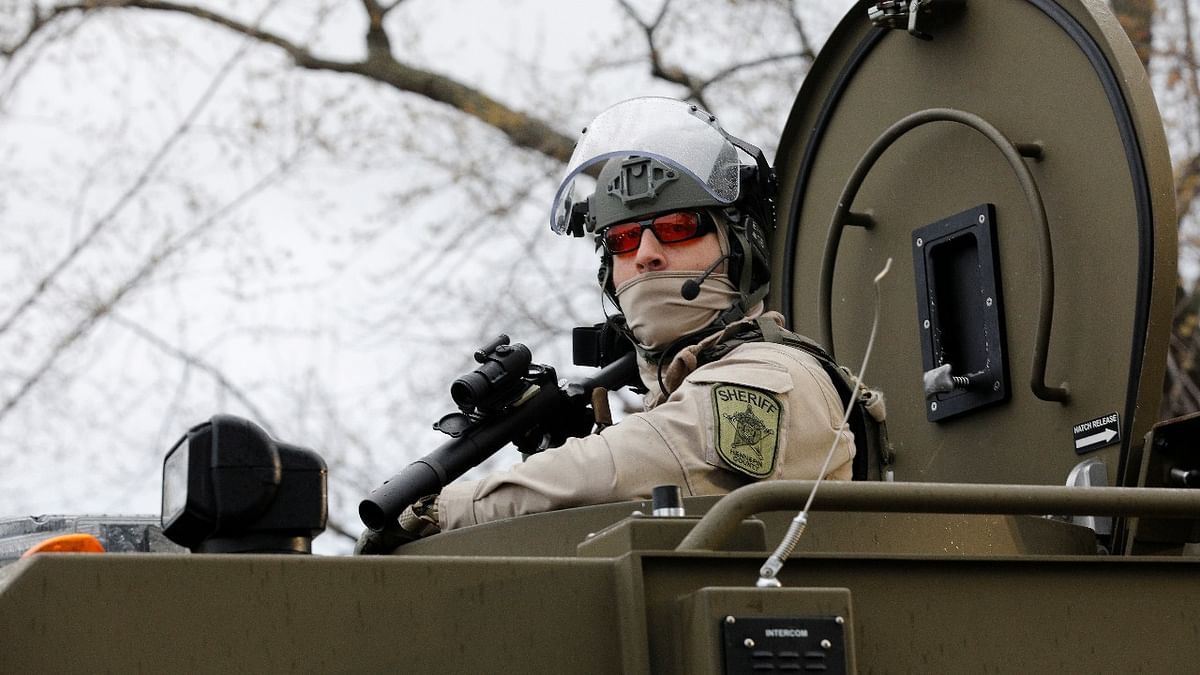 A sheriff's deputy is seen inside an armored vehicle in the fenced up perimeter of the Brooklyn Center Police Department, days after former police officer Kim Potter fatally shot Daunte Wright, in Brooklyn Center, Minnesota. Credit: Reuters photo