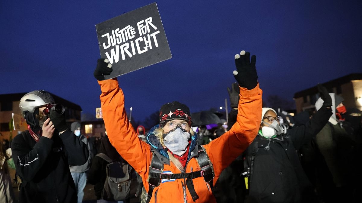A demonstrator holds a sign while gathering near the Brooklyn Center police station on April 14, 2021 in Brooklyn Center, Minnesota. Credit: AFP photo
