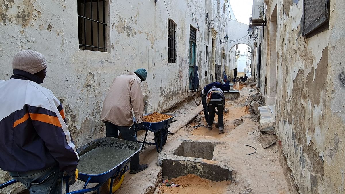 Labourers work on an infrastructure rehabilitation project in an alley of the Libyan capital Tripoli's old city, on March 23, 2021. Credit: AFP photo