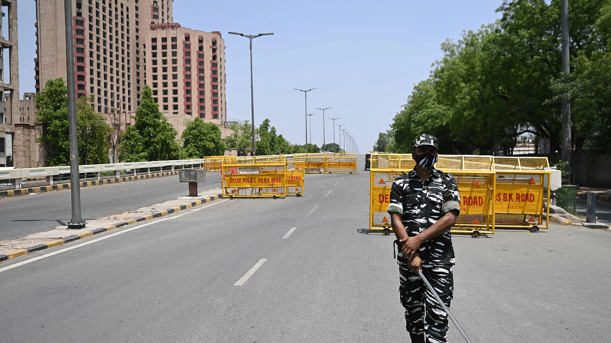 New Delhi | A police personnel can be seen at a checkpoint during a weekend lockdown imposed by the government amidst rising Covid-19 cases. Credit: AFP Photo