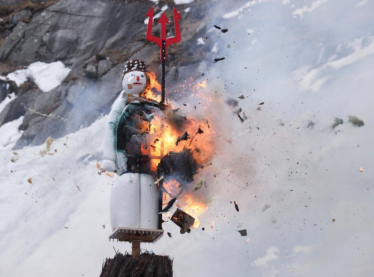 The Boeoegg, a snowman made of wadding and filled with firecrackers, burns in a bonfire on the landmark of Devil's Bridge in the Schoellenen Gorge near the Alpine resort of Andermatt, Switzerland. Credit: Reuters photo.