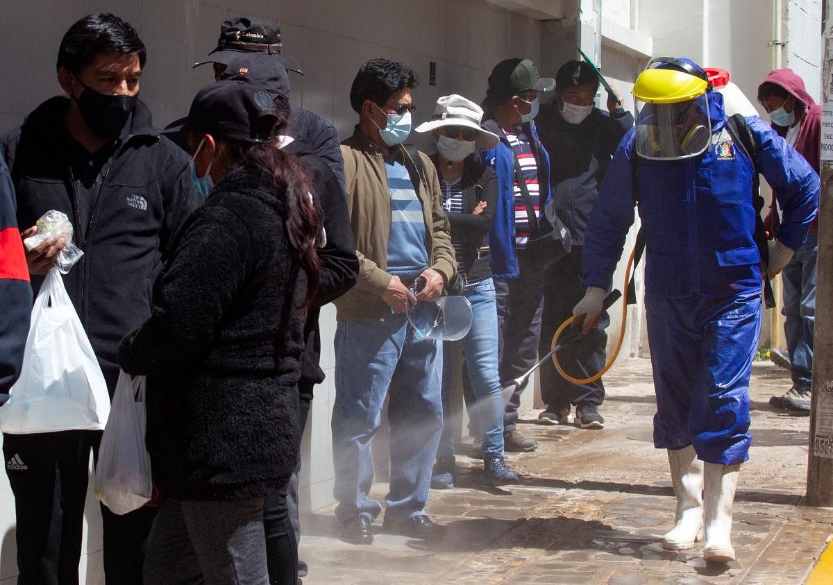 A health worker sprays disinfectant against the spread of Covid-19 in the streets of the Andean city of Puno, Peru, close to the border with Bolivia. Credit: AFP photo.