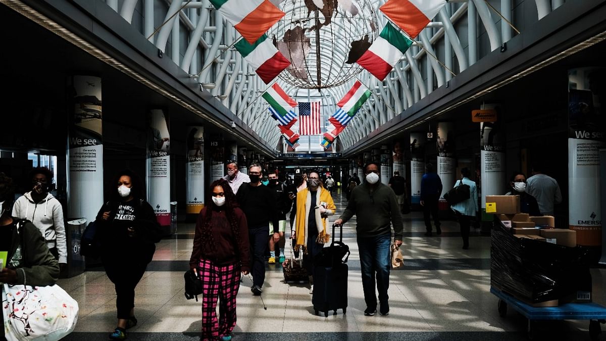 People walk through Chicago O’Hare airport in Chicago, Illinois. As the number of the people vaccinated against Covid-19 increases throughout the nation, people are beginning to travel by air again. Credit: AFP Photo