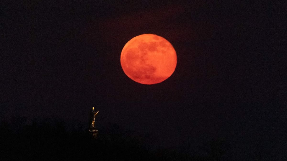 Moon rising behind a statue of the Christ in Wolxheim, eastern France. Credit: AFP Photo