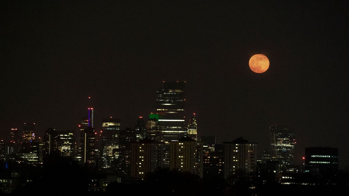 Moon rises over the skyline of London. Credit: AFP Photo