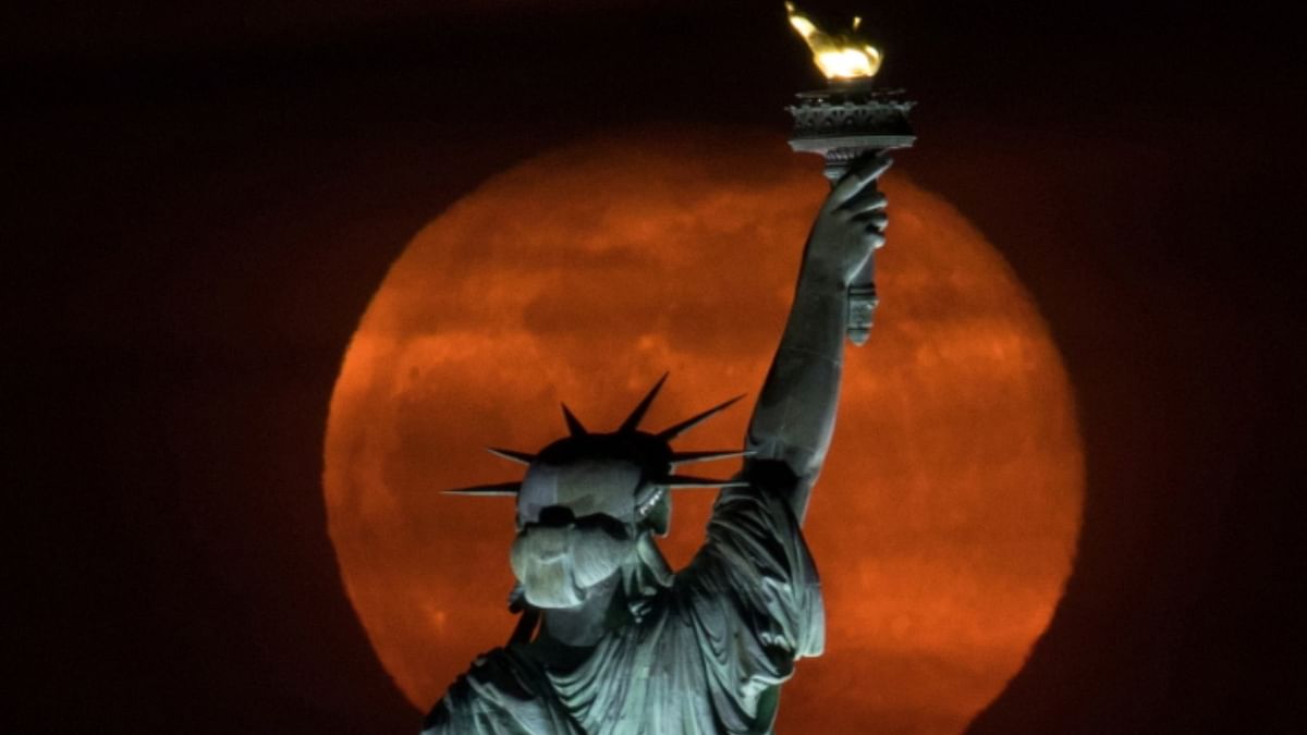 The full moon, known as the Super Pink Moon rises behind the Statue Liberty in New York City, U.S. Credit: AFP Photo