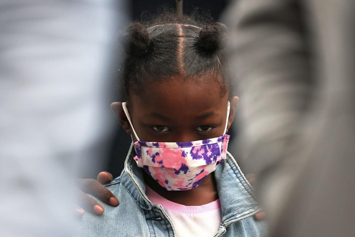 A young child bow's her head in prayer at the start of a peace walk to denounce the rise of gun violence in the city in the Harlem neighborhood. Credit: AFP Photo