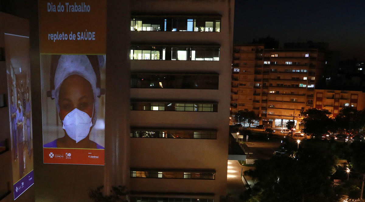 View of an image of a health professional projected on a wall of the Clinics Hospital in Porto Alegre, Brazil, on April 30, 2021, on the even of the International Workers' Day to show gratitude for health workers' commitment to life amid the Covid-19 pandemic. Credit: AFP Photo