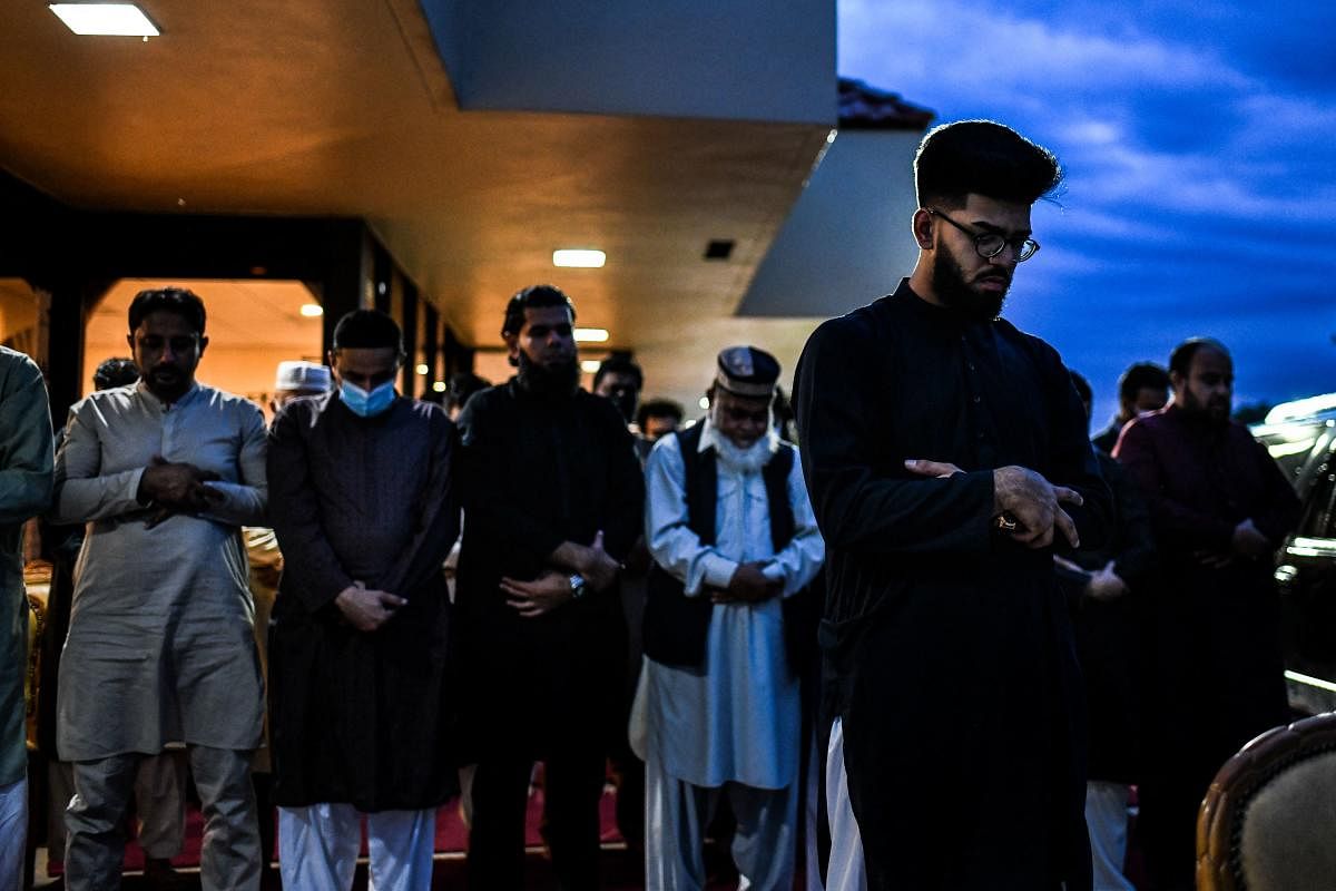 Muslim men offer prayers on the pavement outside a restaurant during the Muslim holy month of Ramadan in Lauderhill. Credit: AFP Photo