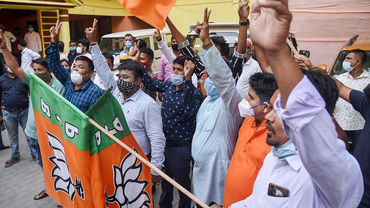 Police personnel stop BJP activists from celebrating as trends show party's win during the counting day of Assam Assembly Poll 2021, in Dibrugarh.
