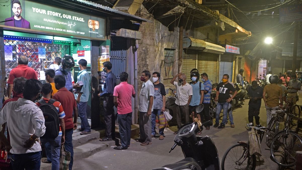 People queue outside a liquor shop after the state government announced restrictions to curb the spread of the Covid-19 coronavirus in Siliguri. Credit: AFP
