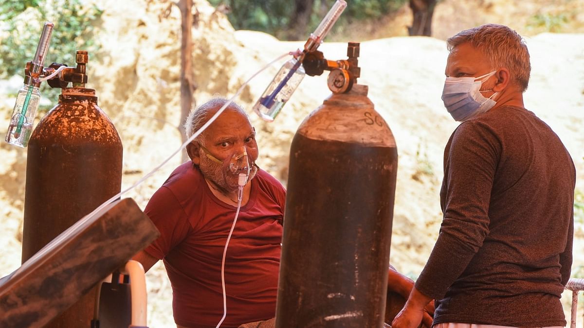 Covid-19 patient uses an oxygen cylinder from an NGO Hemkunt Foundation, which is offering free oxygen cylinders for Covid-19 patients, at Sector 42, in Gurugram.