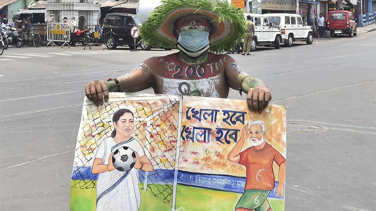 TMC supporter holds a placard outside West Bengal Chief Minister Mamata Banerjee's residence at Kalighat. Credit: PTI