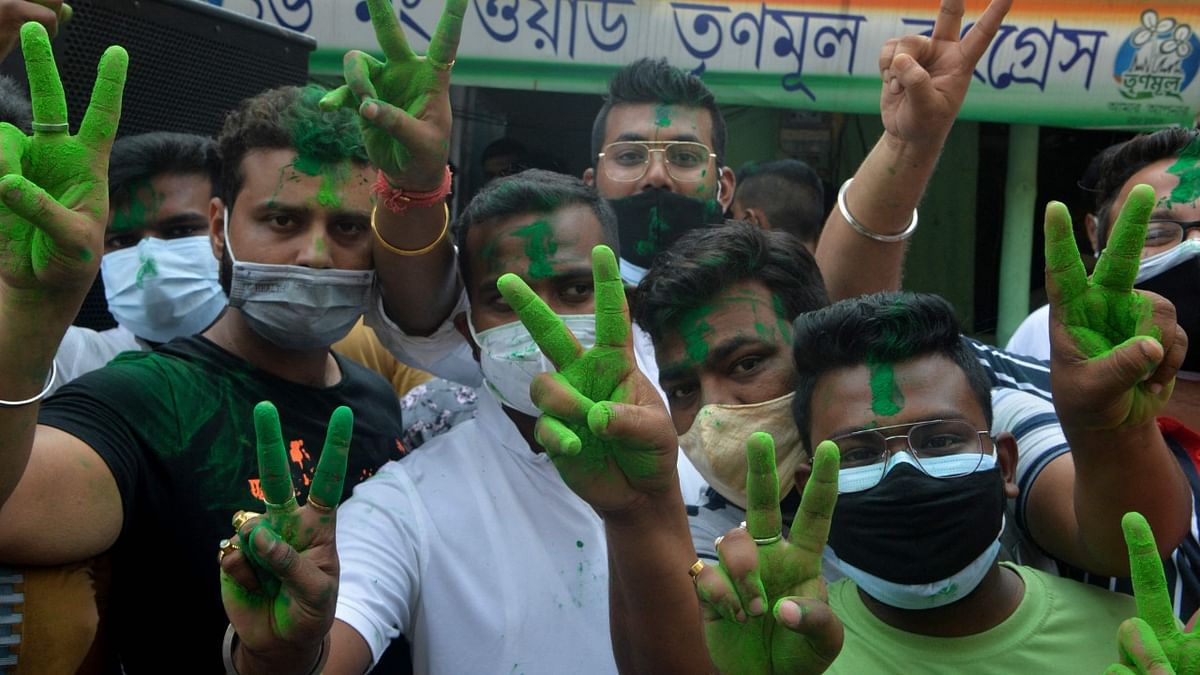TMC party workers show victory sign as they celebrate party's lead. Credit: AFP
