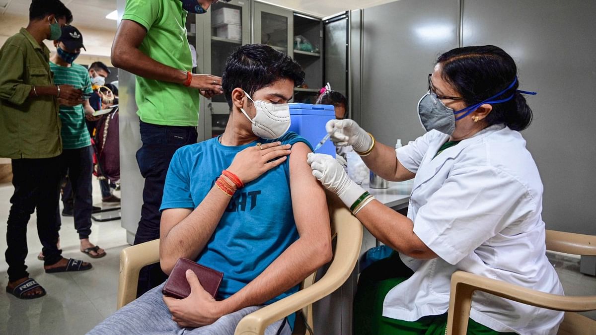 A medic administers a dose of COVID-19 vaccine to above 18 beneficiaries at a vaccination center for Covid-19 at Moti Lal Nehru Medical College, in Prayagraj.