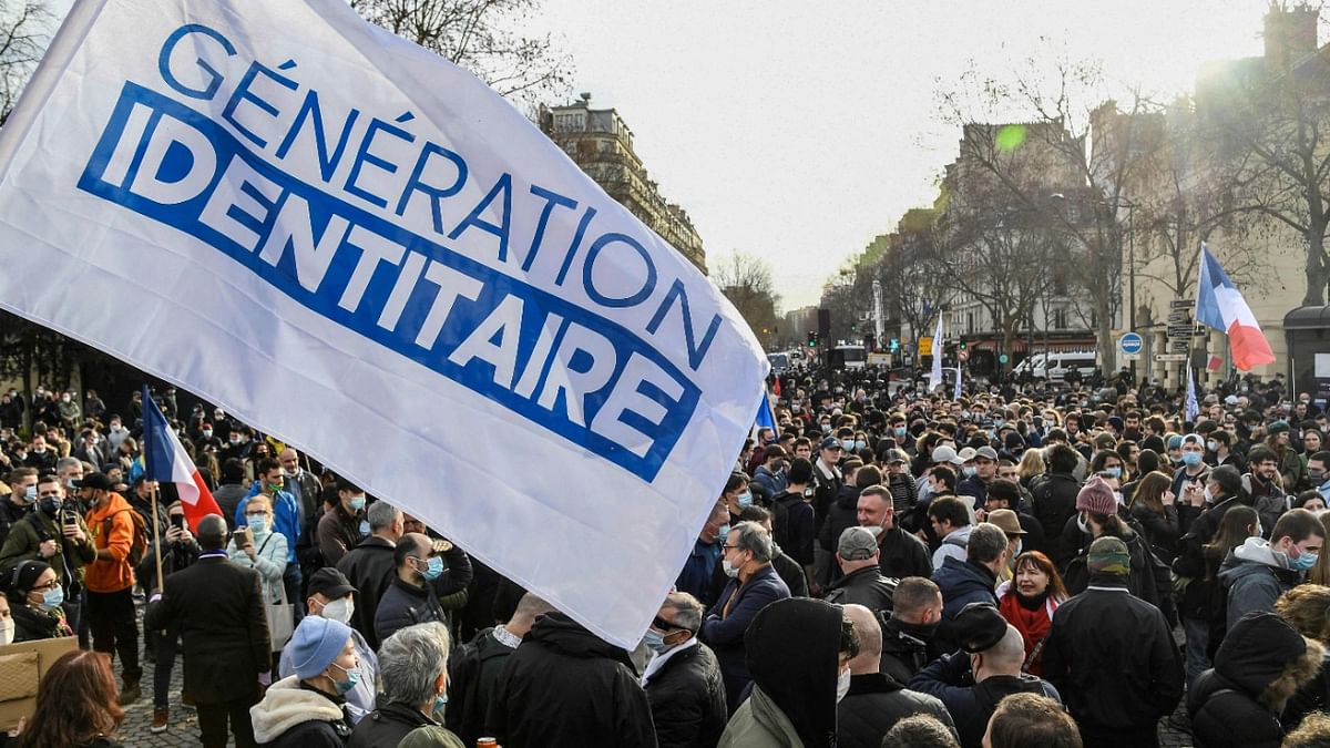 members and supporters of far right group Generation Identitaire (GI) hold a flag during a protest against its potential dissolution in Paris. Credit: AFP Photo