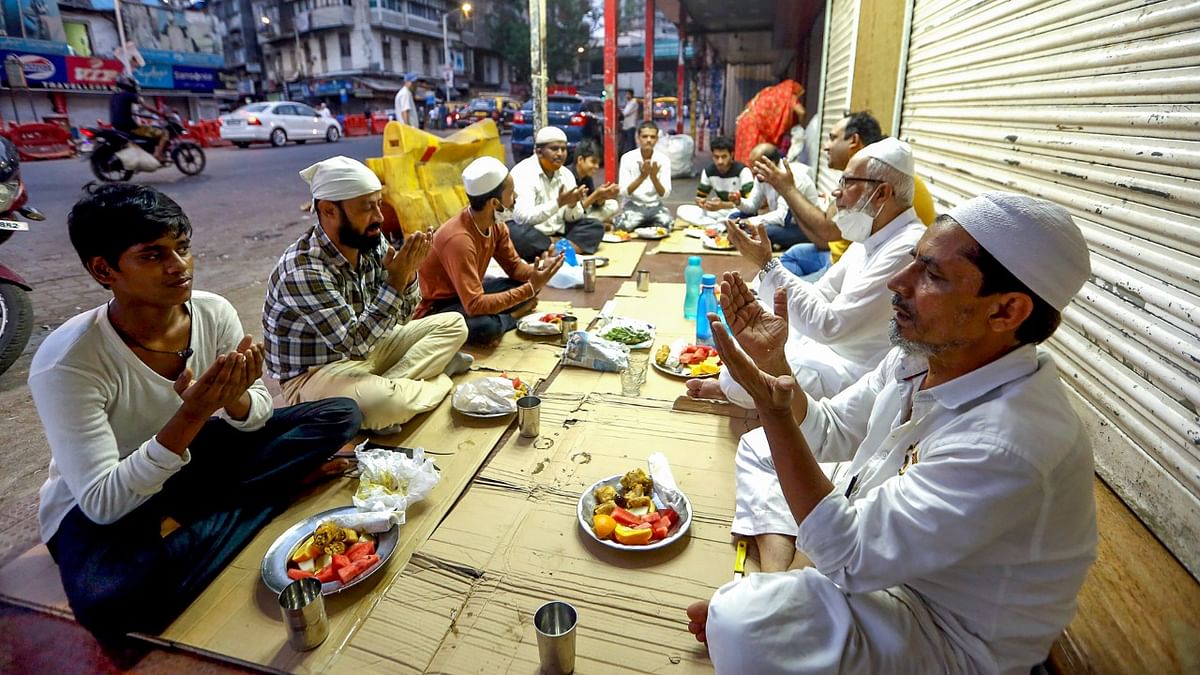 Muslims pray before breaking their day-long fast on the first day of the holy month of Ramzan at a market in Mumbai. Credit: PTI