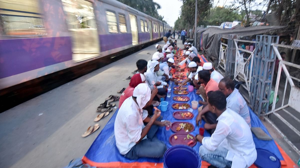 Muslims break their fast on the platform of a railway station during the ongoing holy month of Ramadan, in Kolkata. Credit: PTI