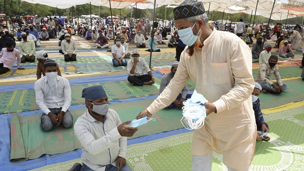 People are given face masks before the prayers during the ongoing holy fasting month of 'Ramadan', at Leisure Valley ground in Gurugram. Credit: PTI