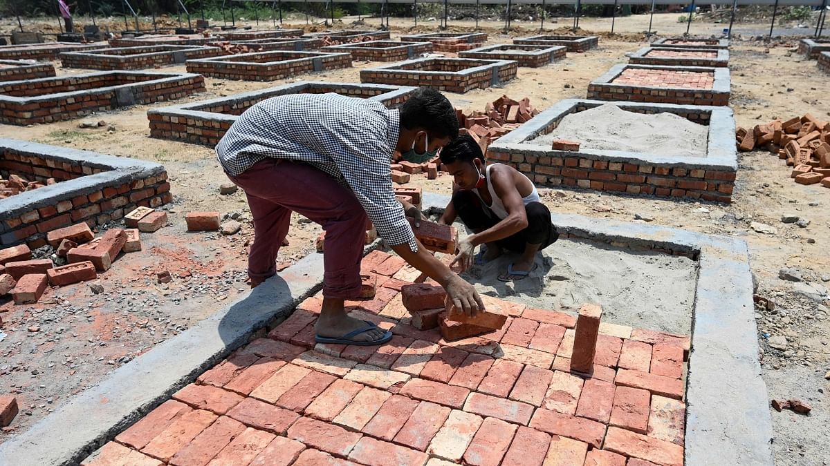 Labourers build new cremation platforms at an empty field in New Delhi.