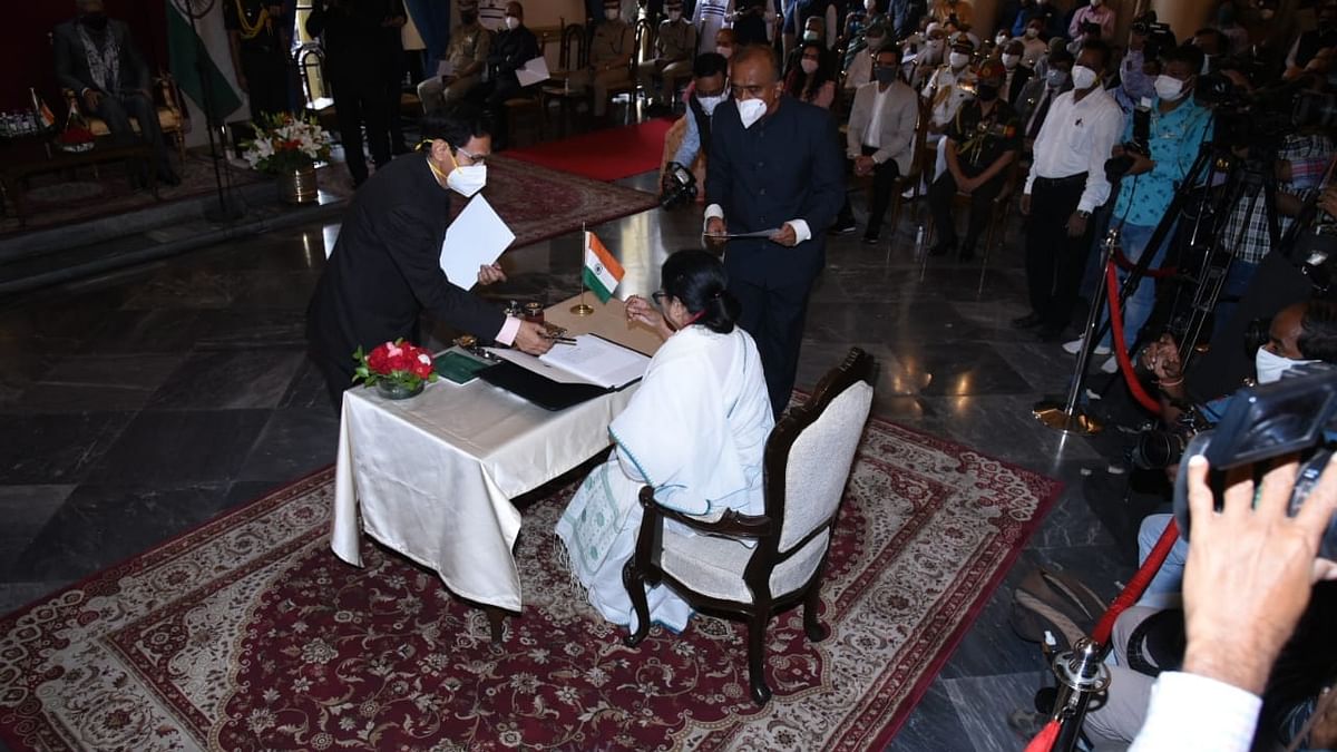 Mamata Banerjee signs the register after taking oath.