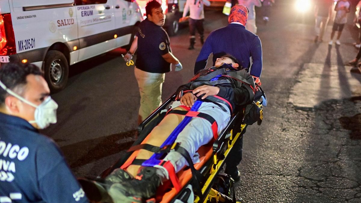 Emergency workers move an injured person on a stretcher at the site of a train accident after an elevated metro line collapsed in Mexico. Credit: AFP