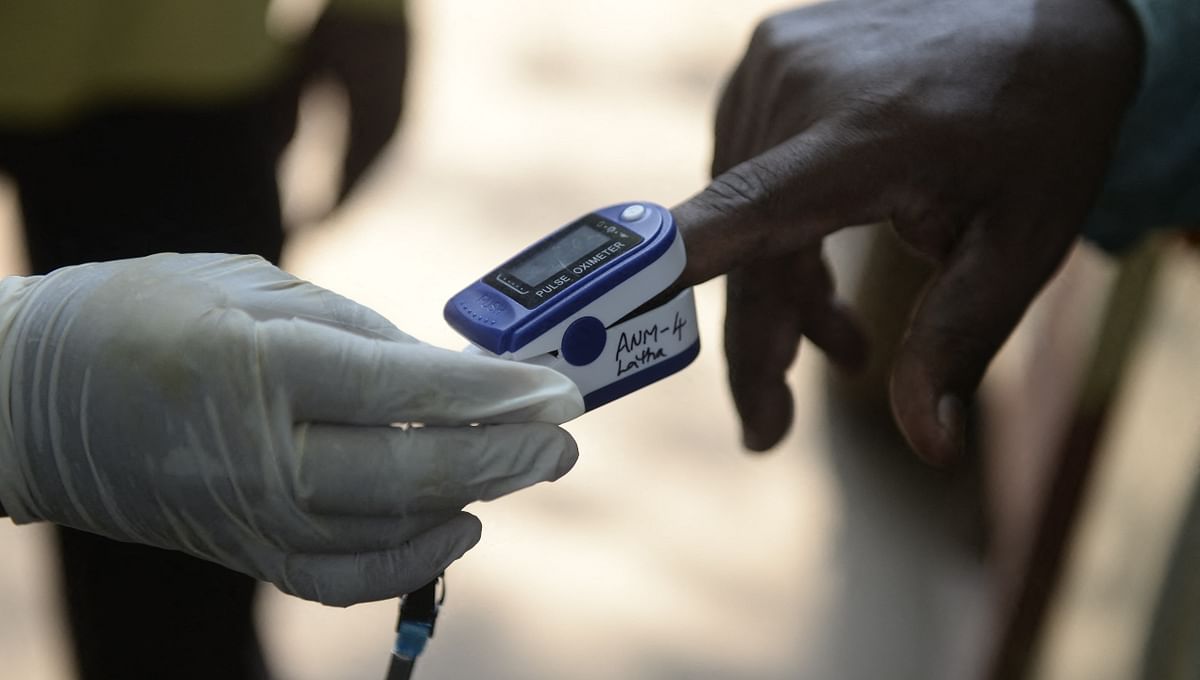 A health worker uses an oximeter to monitor the pulse an oxygen saturation levels of a resident during a door-to-door survey to check for Covid-19 coronavirus symptoms in Hyderabad.